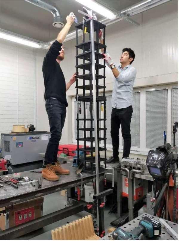 Students assembling a tall dynamic model of a multistory building