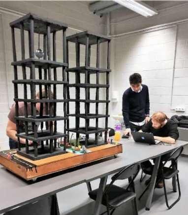 Students working beside a multistory building model